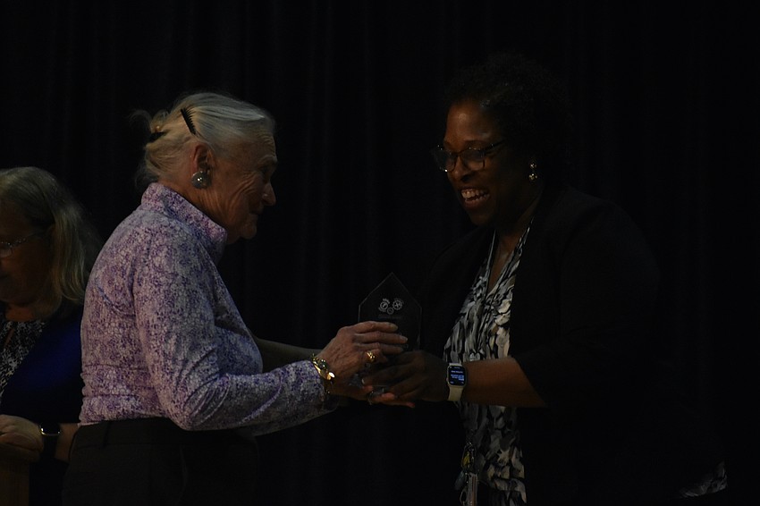 Laura Pardee of Bay Village, one of the school's community partners, accepts her award from Assistant Principal Tammy Miles-Brown.