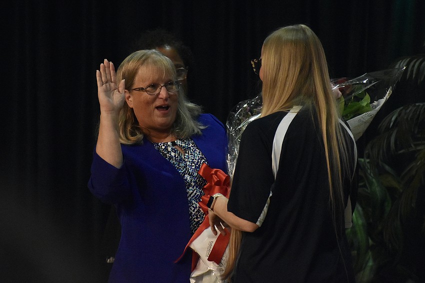 Principal Susan Nations receives flowers from STEAM coach Tessa Healy.