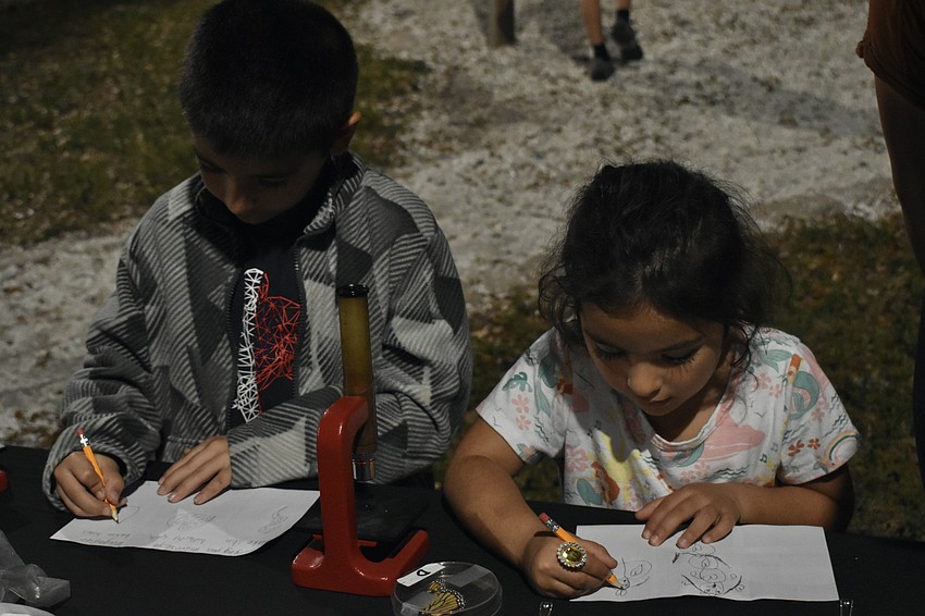 6th grader Yacek Suri and VPK student Evelyn Suri perform a science drawing activity.