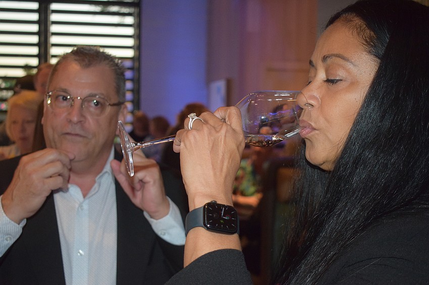 Jeff Rodman instructed guest Yvette Mathis on how different types of water impact the palate after eating caviar at a soft opening event at Fleming's Prime Steakhouse and Wine Bar Saturday.