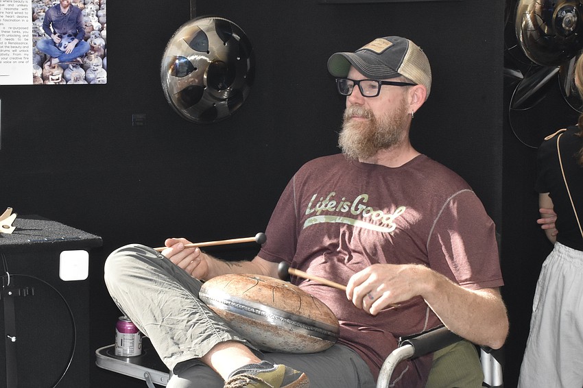 Steel drum artist Jonathan Rose plays a drum to welcome guests to his tent.
