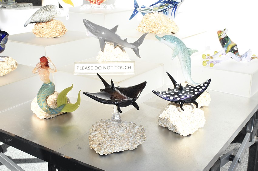 Marine sculptures are on display at a tent.