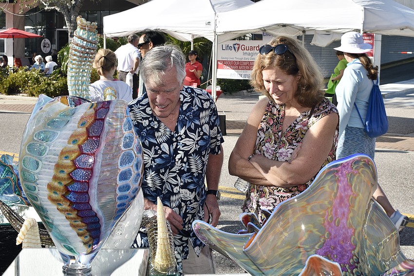 Matt and Kellie Bootman admire a row of sculptures and glasswork.