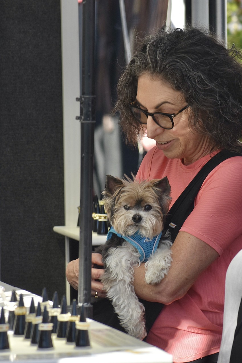 Francine Rosenberg and her dog Moses browse items for sale.