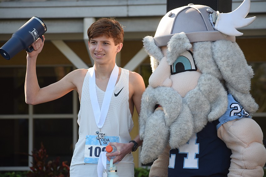 Finn Randall poses with ODA mascot Thor after finishing No. 1 overall at the Tase of ODA 5K with an 18:36, over 30 seconds faster than every other runner.