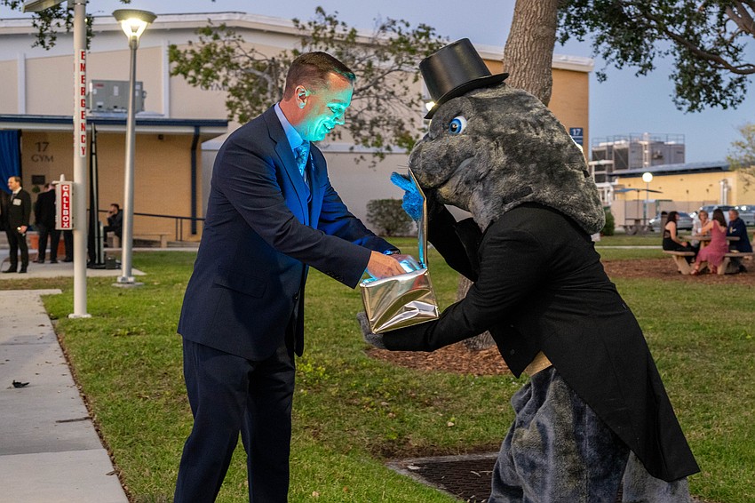 President Tommy Gregory receives the key to the college from Maverick the Manatee.