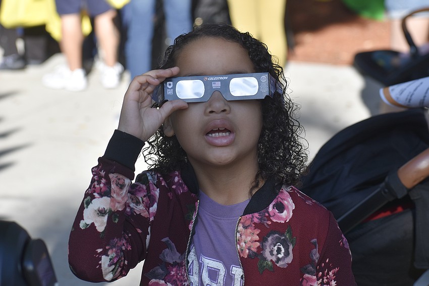Layla Farrell-Cook looks at the sun with a special pair of glasses from Sidewalk Science Center.