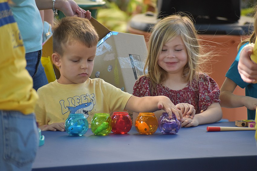 Mark Sumegi, 4, sorts fish into different colored bowls, as Violet Moore, 3, watches.
