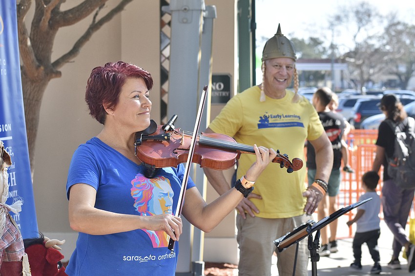 Carlann Evans of the Sarasota Orchestra, and Dan Raker, greet guests as they enter the event. Evans said her favorite part of the experience is 