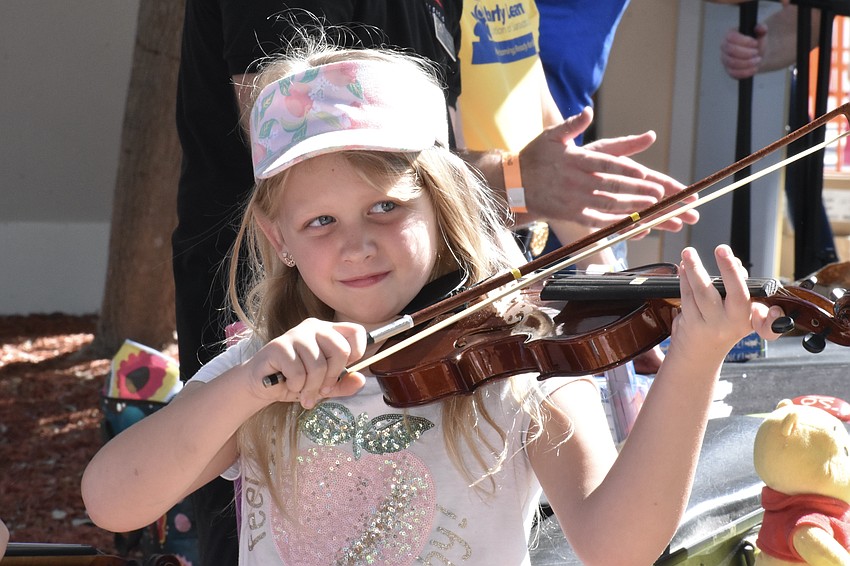 Ellianna Lyday, 8, takes a turn in the role of a Sarasota Orchestra member.