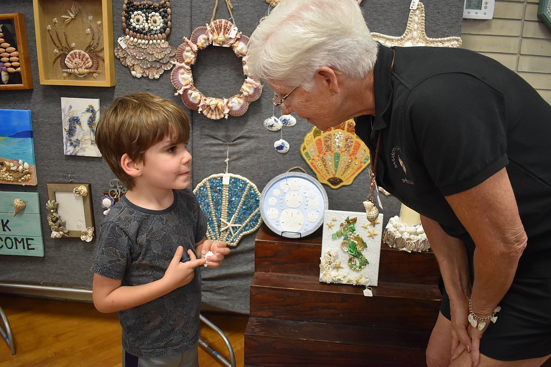 Enzo Frascone, 4, asks Debby Alexander to help him identify a shell.