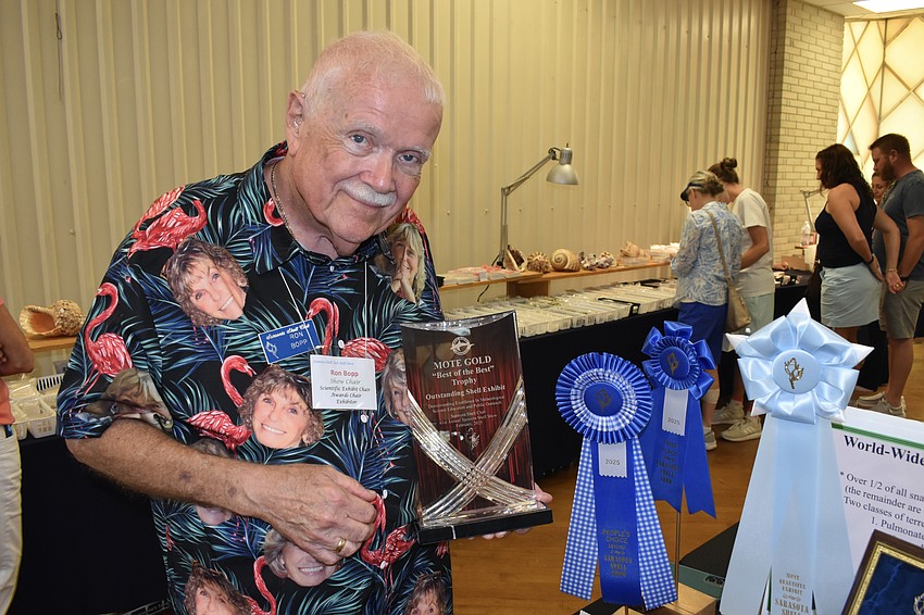 Ron Bopp, chair of the scientific exhibits, showcases the awards he won this year for his exhibit from his personal collection, including the Mote Gold award.