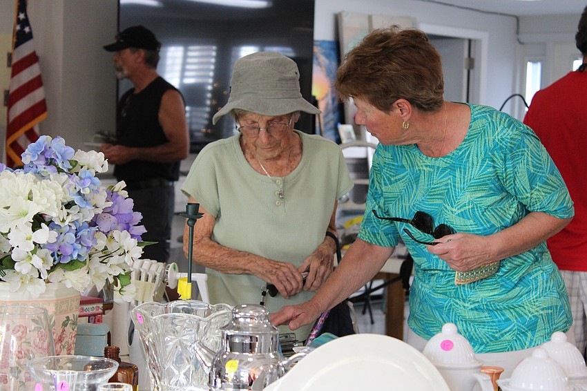 Shopping pals Stella Kelley and Mary Lou Ivaska peruse the selection at the early bird Trash to Treasure rummage sale.