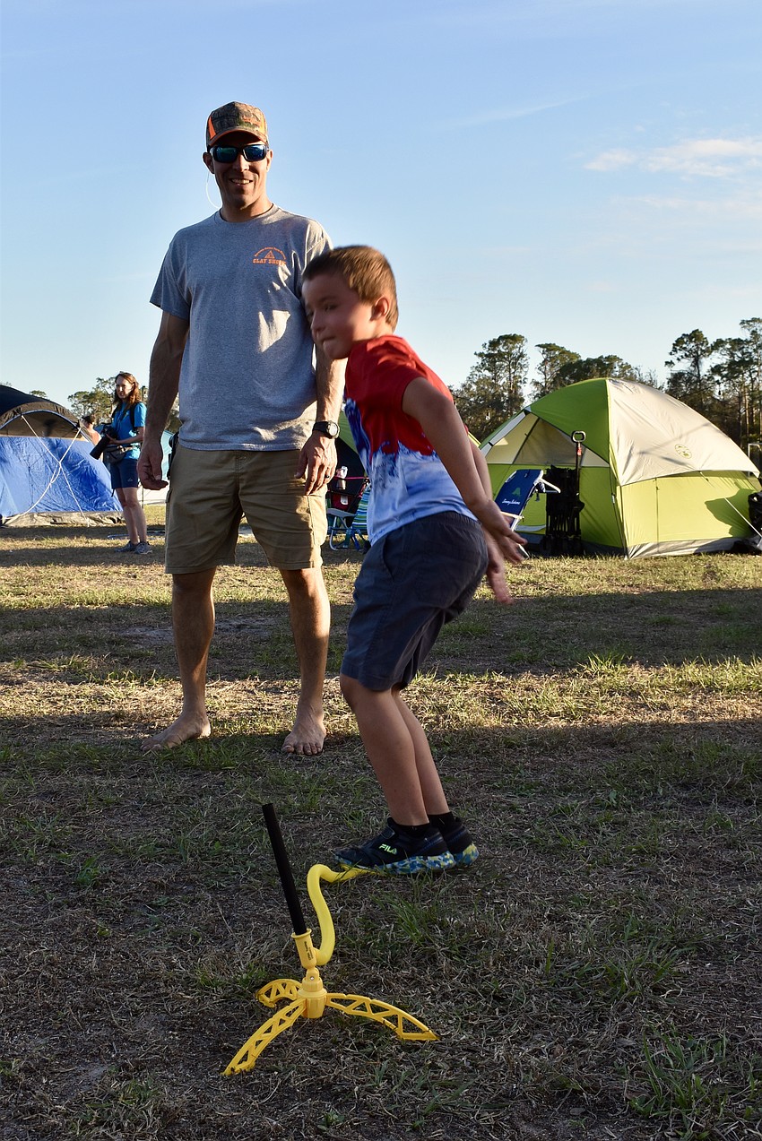 Dan Barshinger looks on as his 7-year-old son Zane sets off a stomp rocket.