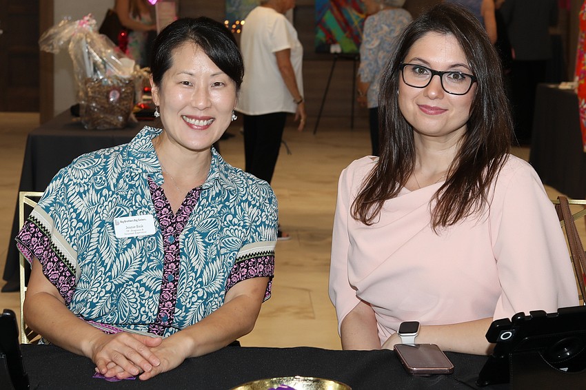 Jeanie Baik and Vera Poskotina assist with check-in.