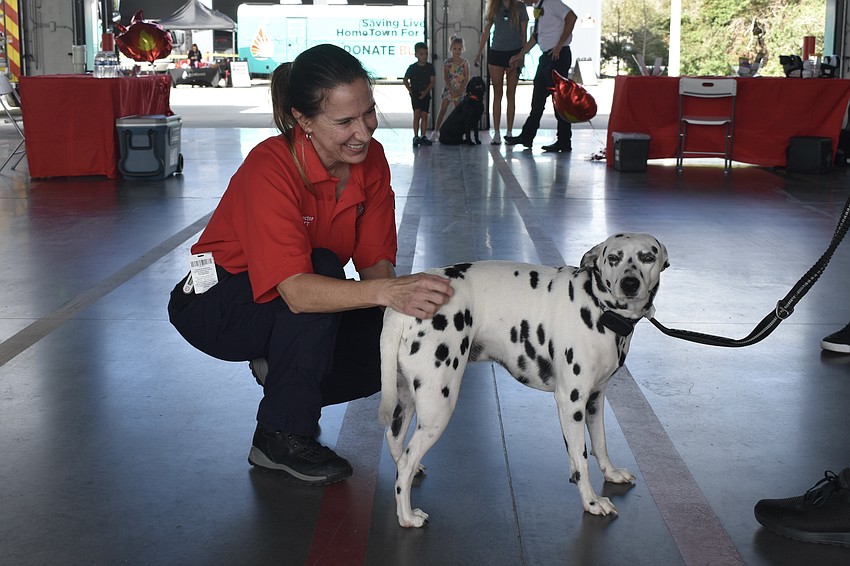 Fire Inspector Susan Scott pets Brisa, who comes from the Humane Society of Sarasota County.
