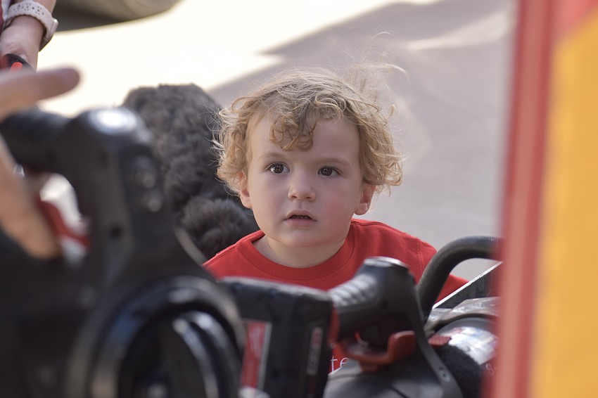 Nate Brown, 1, from Venice, learns about the extrication tools from Firefighter/EMT Justin Foster.