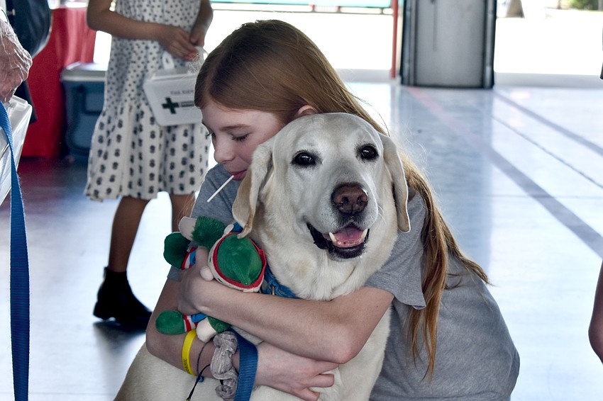 Sarasota's Miaha Pasickgerdman, 11, gives a hug to Bear, who comes from the Humane Society of Sarasota County.