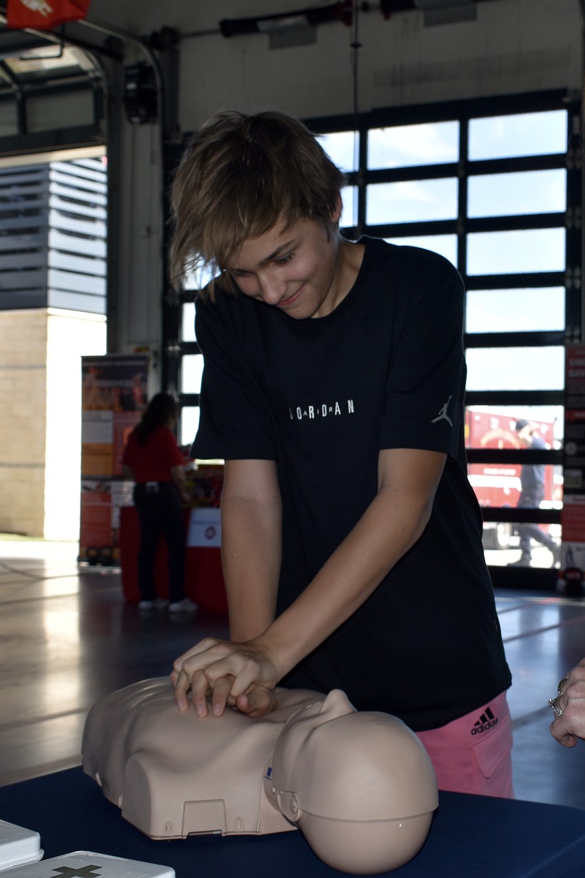 Sarasota's Matt Pirogov, 13, practices CPR at the Sarasota Memorial Hospital table.