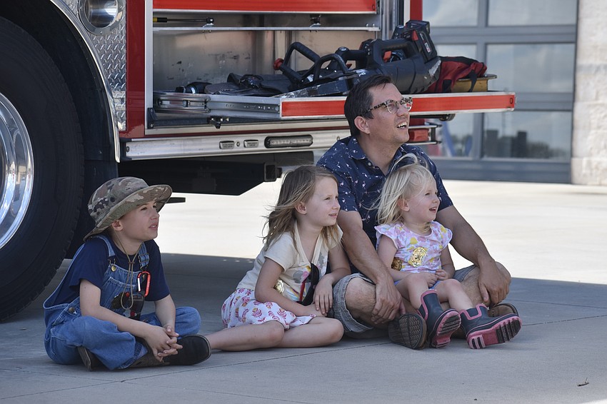Malcolm Drummond, 7, Charlotte Drummond, 6, Elizabeth Drummond, 2 and their father Scott Drummond, watch the rapelling demonstration. They drove from Arcadia to see the open house.