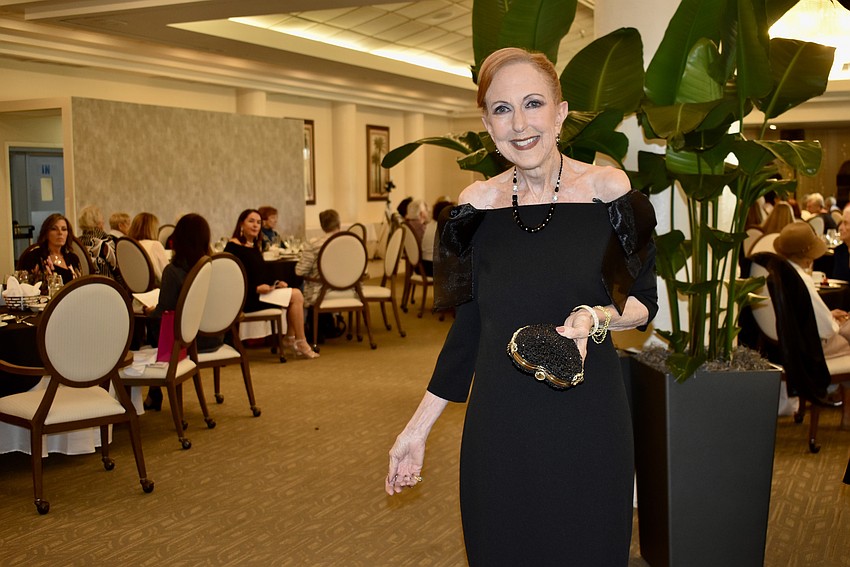 Emcee Darcie Jacob calls the dress Susan Romine is modeling 