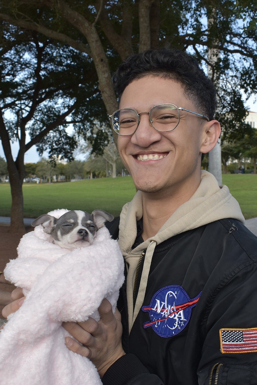 Francisco Pinto holds Valentine, a pup belonging to sisters Stephanie and Elizabeth Torres.