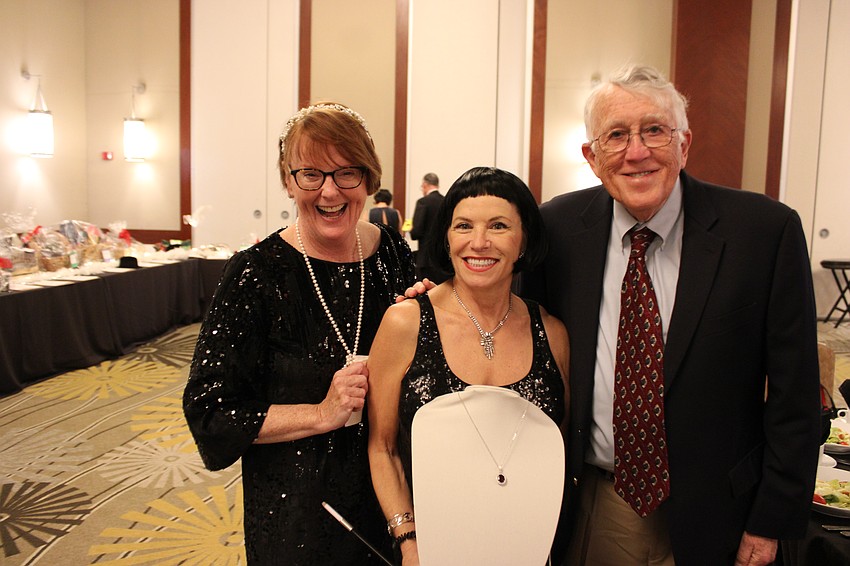 Patty Kane, Angela Massaro-Fain, and Mike Kane show off a necklace that would be featured in the live auction at All That Jazz: Cabaret for a Cause.