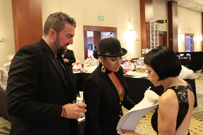 David Perkowski and Allison Imre Perkowski check out a live auction necklace shown to them by Sisterhood for Good founder Angela Massaro-Fain.