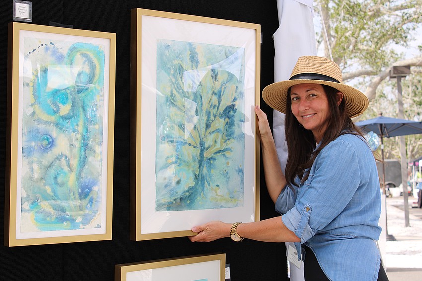 Sarah Diana readjusts one of her watercolors on display.