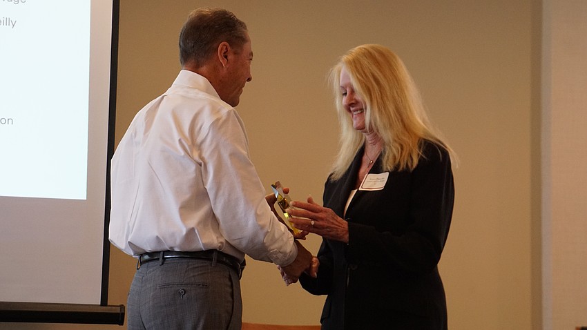Assistant to the Town Manager and Public Information Officer Susan Phillips accepts an award from H. Joseph Reiser.