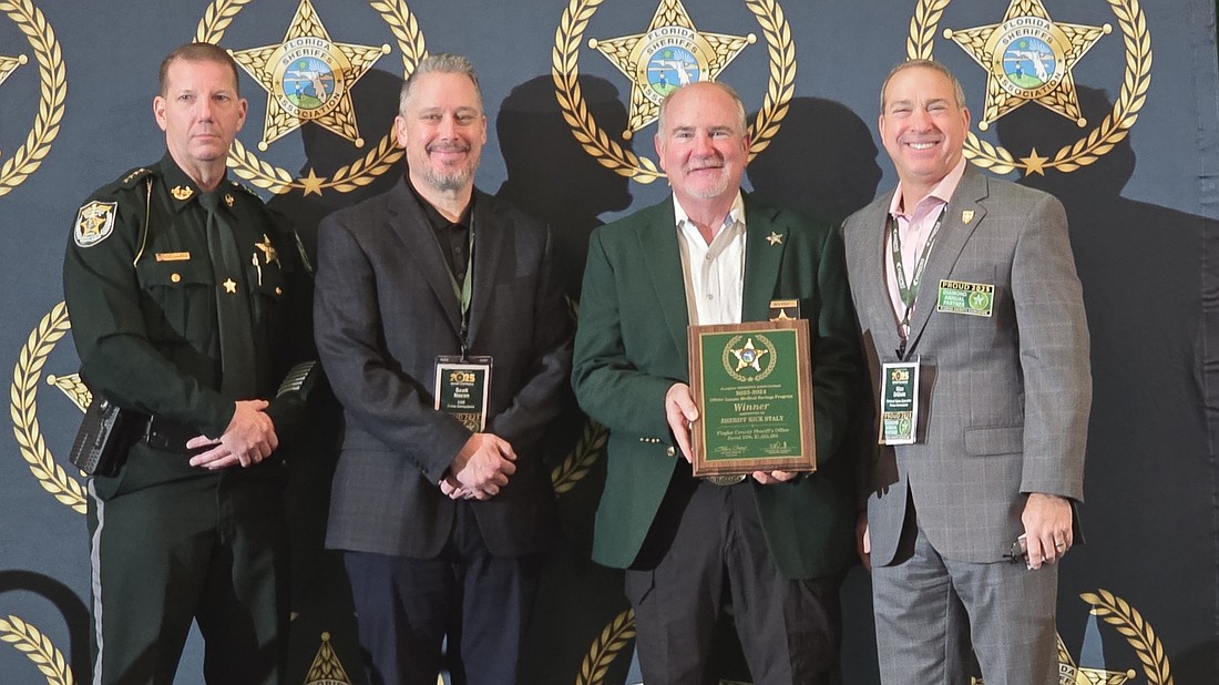 Flagler County Sheriff Rick Staly (second from right) is presented the award as the top saver through the Offsite Inmate Medical Savings Program by Florida Sheriffs Association President and Charlotte County Sheriff Bill Prummell, Prime Health Services Chief Operating Officer Scott Nocon, and Prime Corrections National Sales Executive Nico DiGioia. Courtesy photo