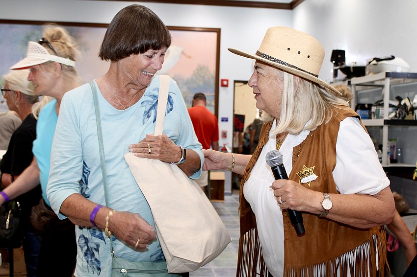 “Sheriff of Rummage” Ginny Akhoury greets shopper Jeanne Baird at the St. Mary, Star of the Sea, Catholic Church annual rummage sale on Friday.