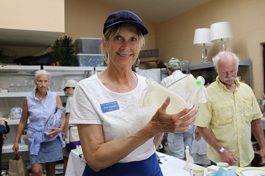 Terri Leonard showcases a handcrafted glass piece from the Italy-based brand Murano Glass at the rummage sale.