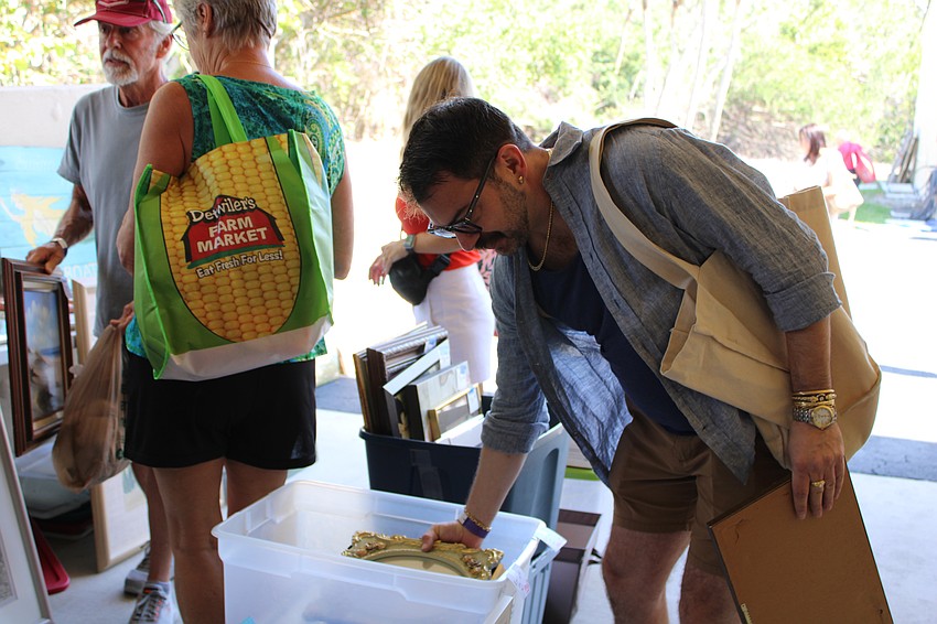 Andrew Bruchey from Boston sifts through the art offerings at the St. Mary, Star of the Sea, Catholic Church sale.