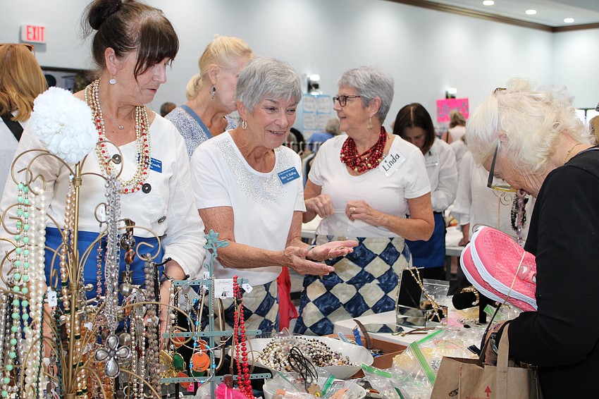 Mary Del Pup assists an early-bird shopper in jewelry.