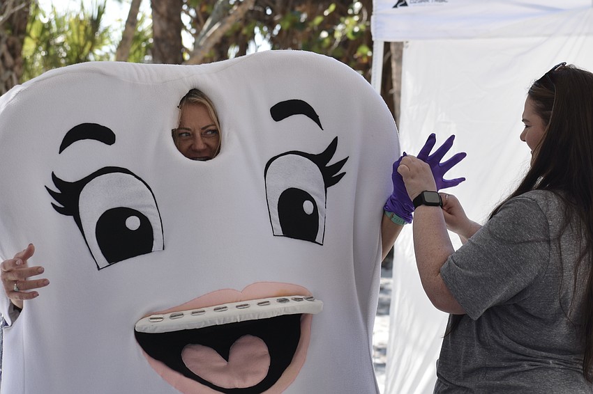 Super Tooth of Varone Orthodontics receives a glove from Ally Paige.