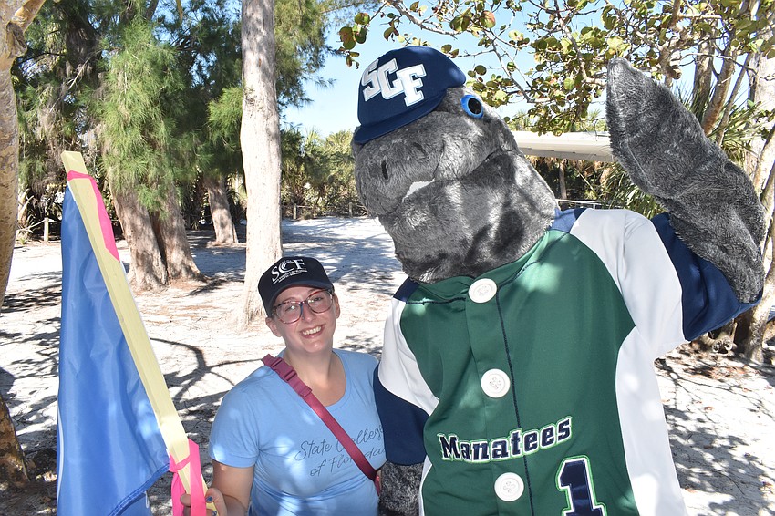 State College of Florida's Madeline Mangas poses with Maverick the Manatee.