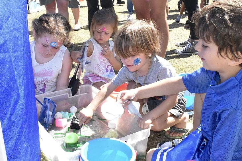 Everleigh Jaworski, 5, Skyler Jaworski, 3, Russ Noto, 3, and Alexander Lido, 5, fish plastics from the water.