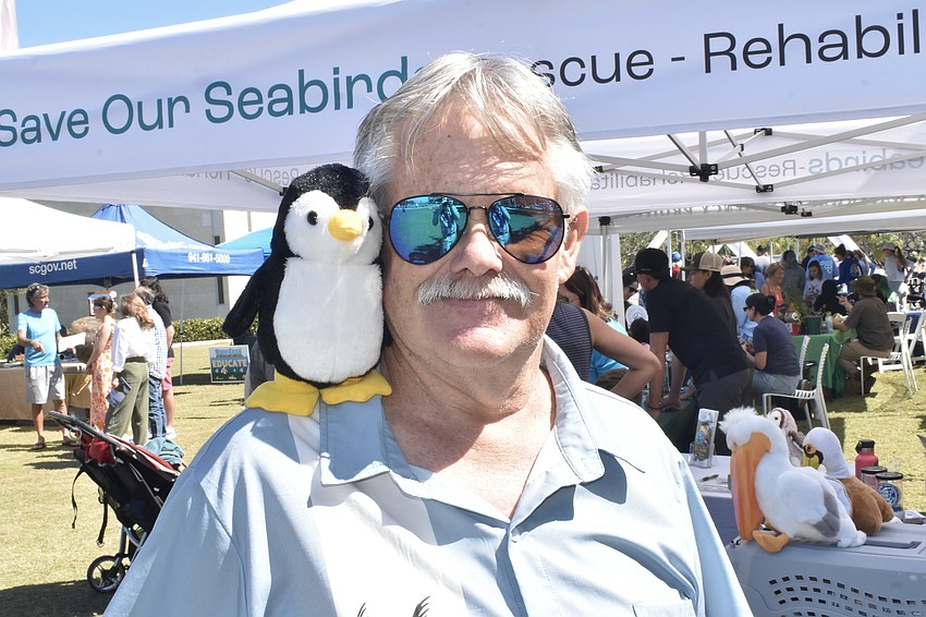 Save Our Seabirds volunteer John Larsen poses with a penguin.