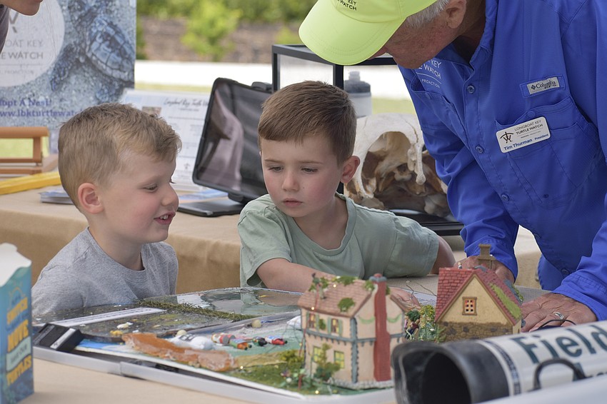Paxton Kaiser, 4, and Lincoln Kaiser, 4, learn from Tim Thurman at Longboat Key Turtle Watch.