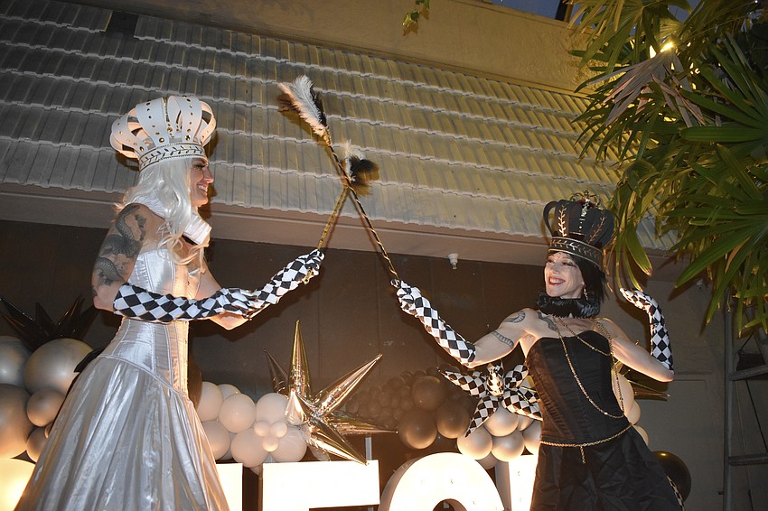Performers Ananda Springsteen and Leaflin Winecoff walk on stilts outside Michael's on East. The event's performers were present thanks to Monet Sexauer, a parent at the school, who previously owned a performing business in California.