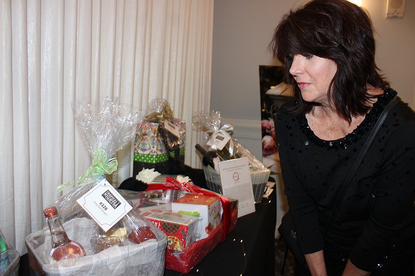 Bradenton's Susan Harrigan checks out auction items at Tropical Nights.