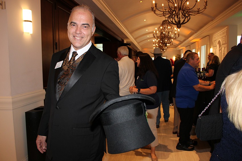 Frank Perry welcomes guests to Tropical Nights with a tip of his tophat. Perry is a Meals on Wheels vice president. He says he loves seeing the community coming together and buying into the mission.