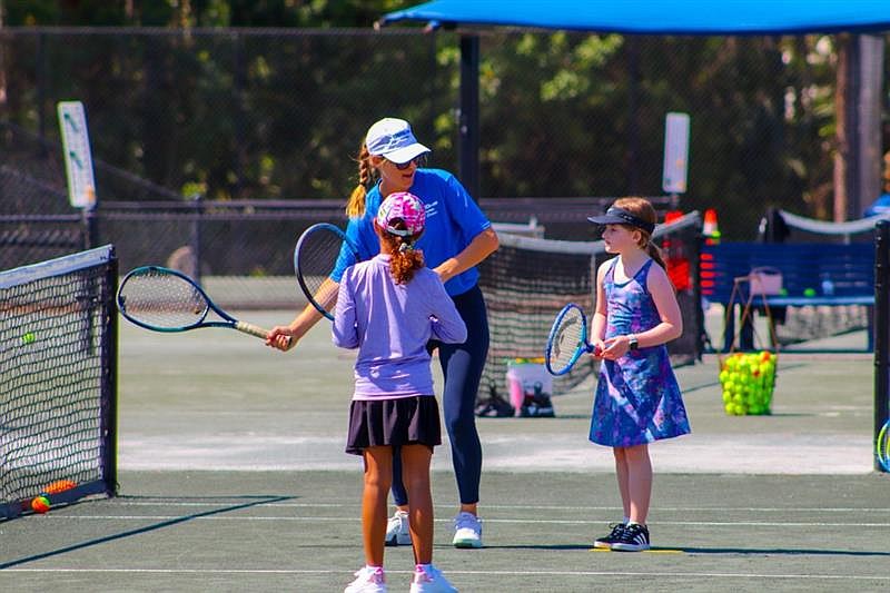 Two young girls receive tennis tips during the USTA Florida Community Outreach Day at the Southern Recreation Center. Courtesy photo