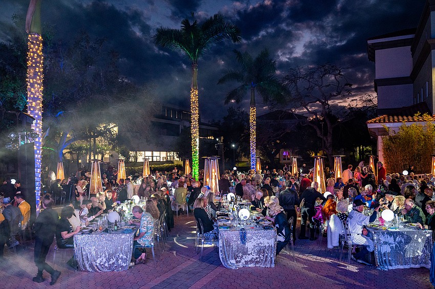 Guest are seated for dinner in the courtyard.