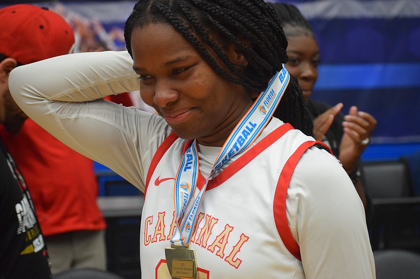 Cardinal Mooney senior Sy'monique Simon smiles after receiving her gold medal for winning the 3A state championship over Bolles at the RP Funding Center in Lakeland on March 1.