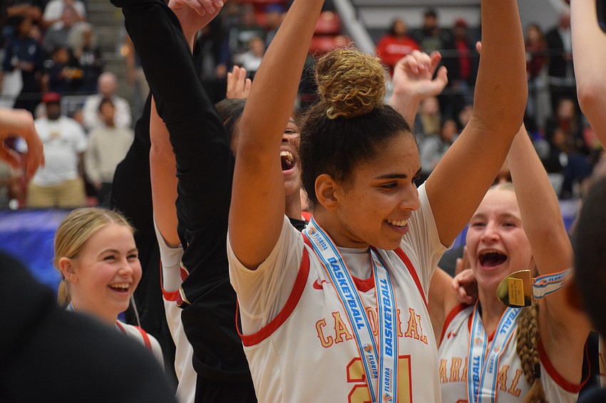 Cardinal Mooney senior Kali Barrett lifts the 3A state championship trophy in triumph after defeating Bolles 64-54 at RP Funding Center in Lakeland.