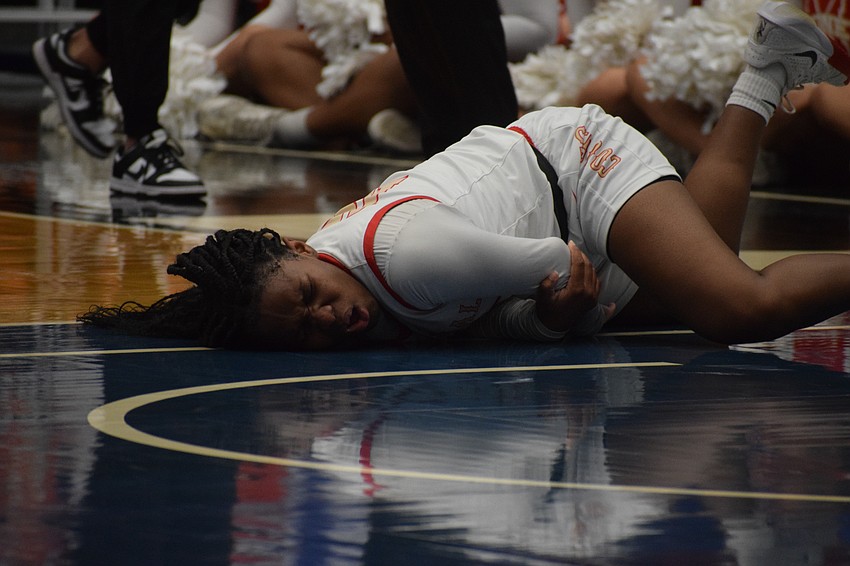 Cardinal Mooney senior guard Sy'monique Simon grimaces as she grabs her elbow shortly after dislocating it during the 3A state championship game against Bolles.