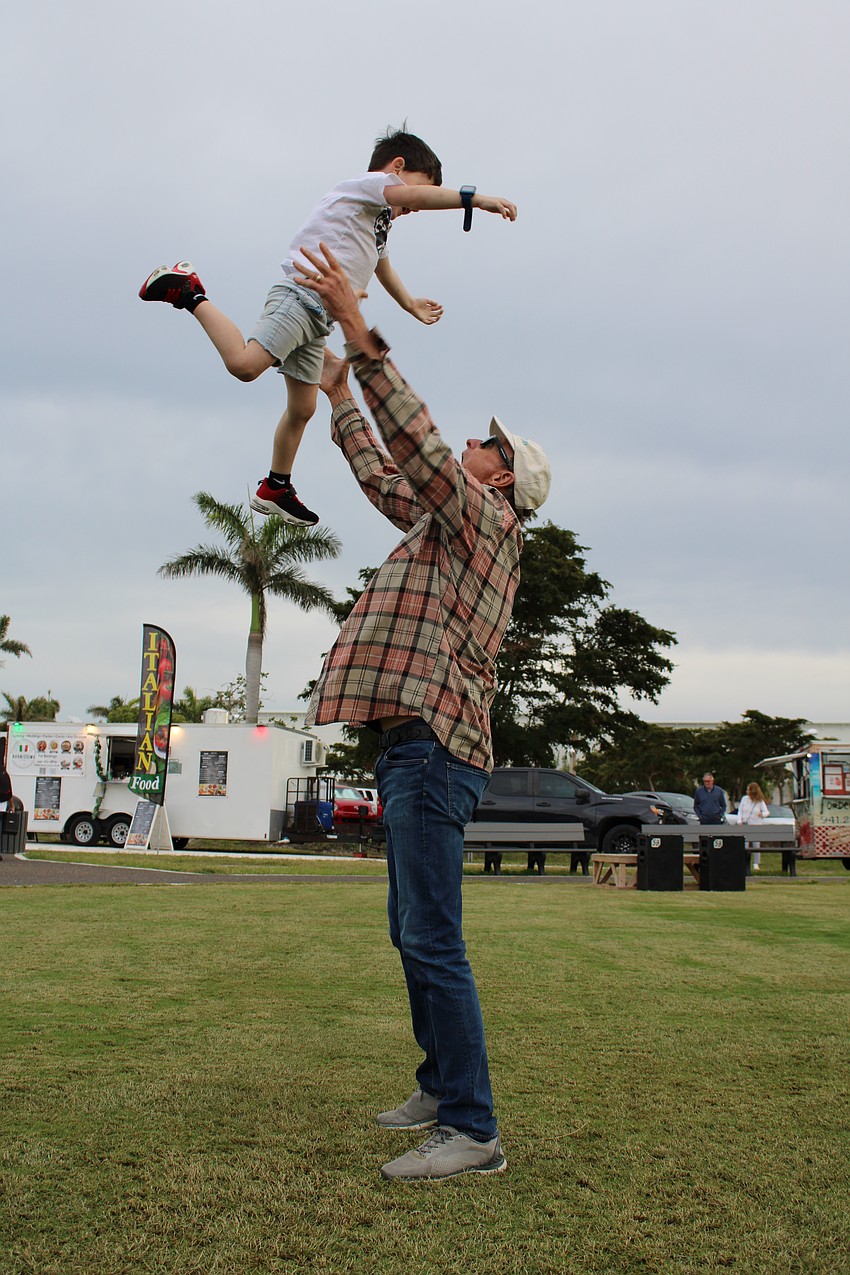 Commissioner Gary Coffin gives Jack Helme a toss in the air as they enjoy an evening out at the concert.