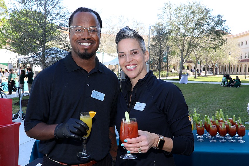 Stefon Jones and Jennifer Craig from The Grove serve drinks as guests enter Brunch by the Bay.